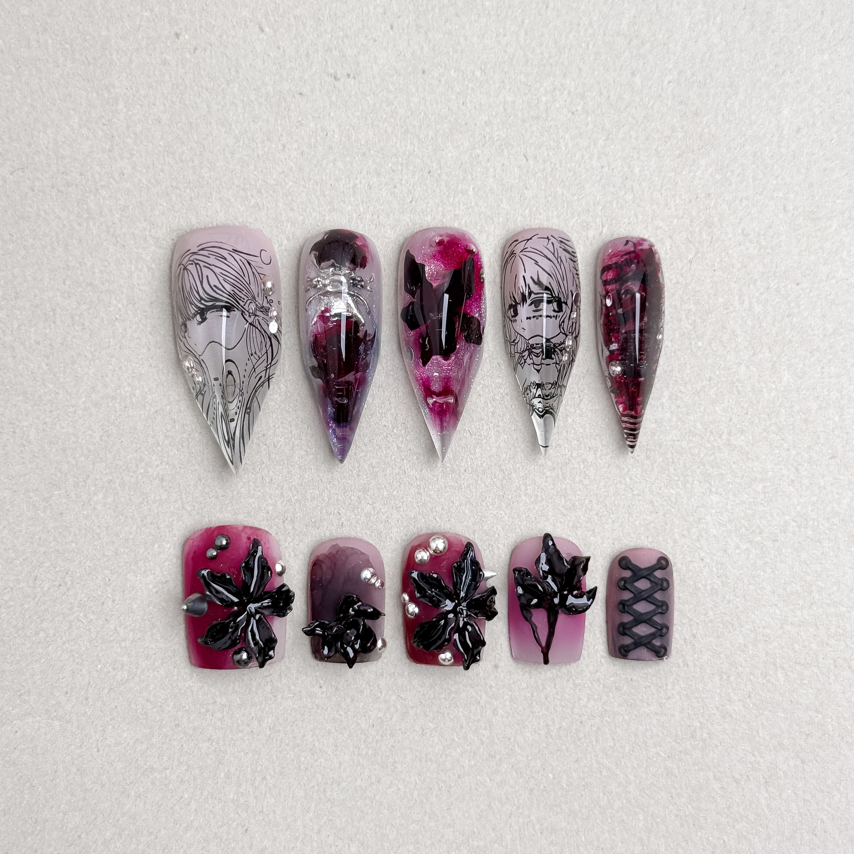 Gothic-inspired press-on nails featuring deep burgundy tones, black accents, and crystal embellishments