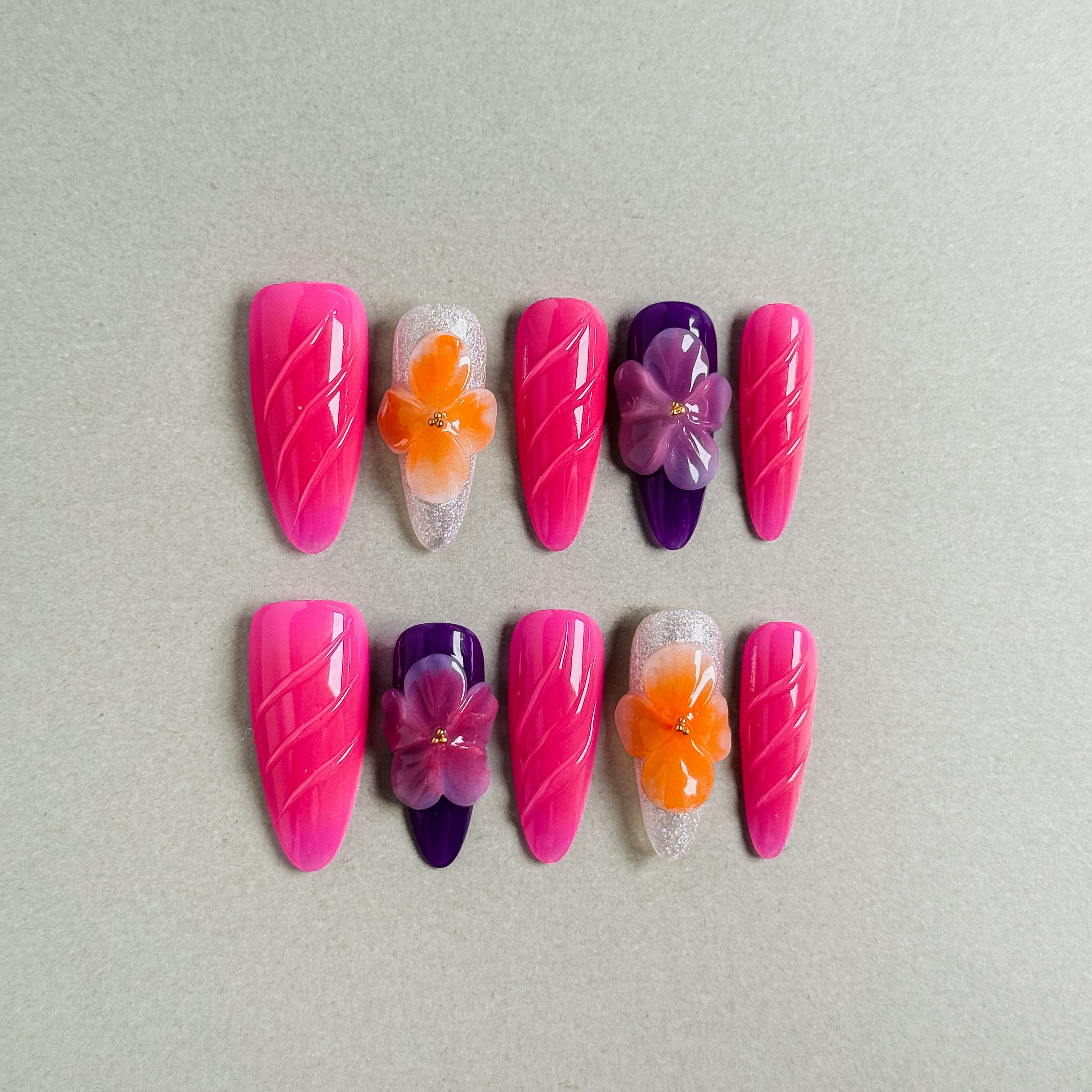 Vibrant Hot Out press on nails with striking pink and purple gradients and colorful flower embellishments, featuring Nail art designs and Glitter nails, perfect for Party nails