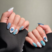 Elegant Almond nails featuring a shimmery blue and white design with heart accents. These Glitter nails offer a sparkling and eye-catching look, perfect for Party nails or special occasions. The intricate details and heart embellishments highlight the artistry of these Handmade press on nails. Ideal for those seeking Luxury press on nails that are both stylish and romantic.