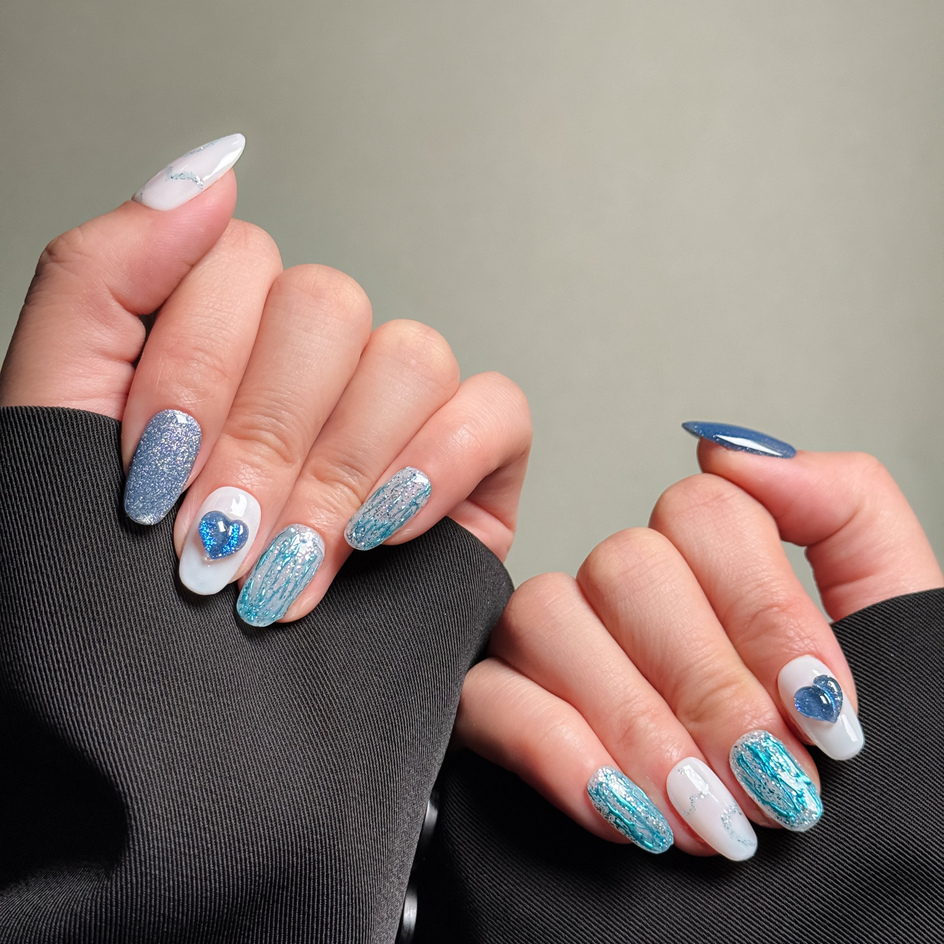 Elegant Almond nails featuring a shimmery blue and white design with heart accents. These Glitter nails offer a sparkling and eye-catching look, perfect for Party nails or special occasions. The intricate details and heart embellishments highlight the artistry of these Handmade press on nails. Ideal for those seeking Luxury press on nails that are both stylish and romantic.