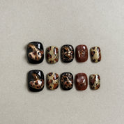 A set of "Savanna" press - on nails with a striking combination of black, brown, and gold, mimicking wild patterns, ideal for adding an adventurous and stylish touch to party nail designs.
