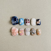 A set of "Faded" press - on nails showcasing a range of colors and intricate designs, including floral motifs, glitter, and stone - like textures, perfect for making a statement at parties with unique nail art.
