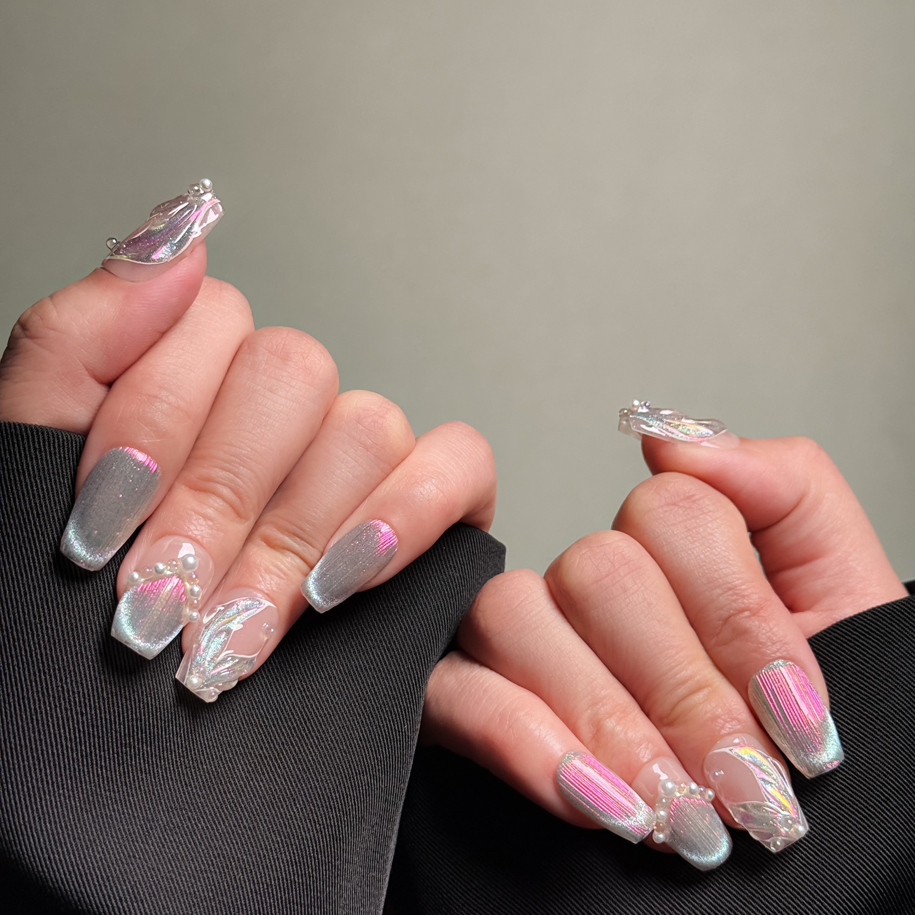 Hands showing MIBLAB's 3D press-on nails with silver glitter and pearl accents, styled in Coffin nails shape. Features iridescent finish and nail accessories for a unique look. Ideal for party nails or holiday nails, showcasing luxury press on nails. Offers handmade press on nails look with professional nail art detail.