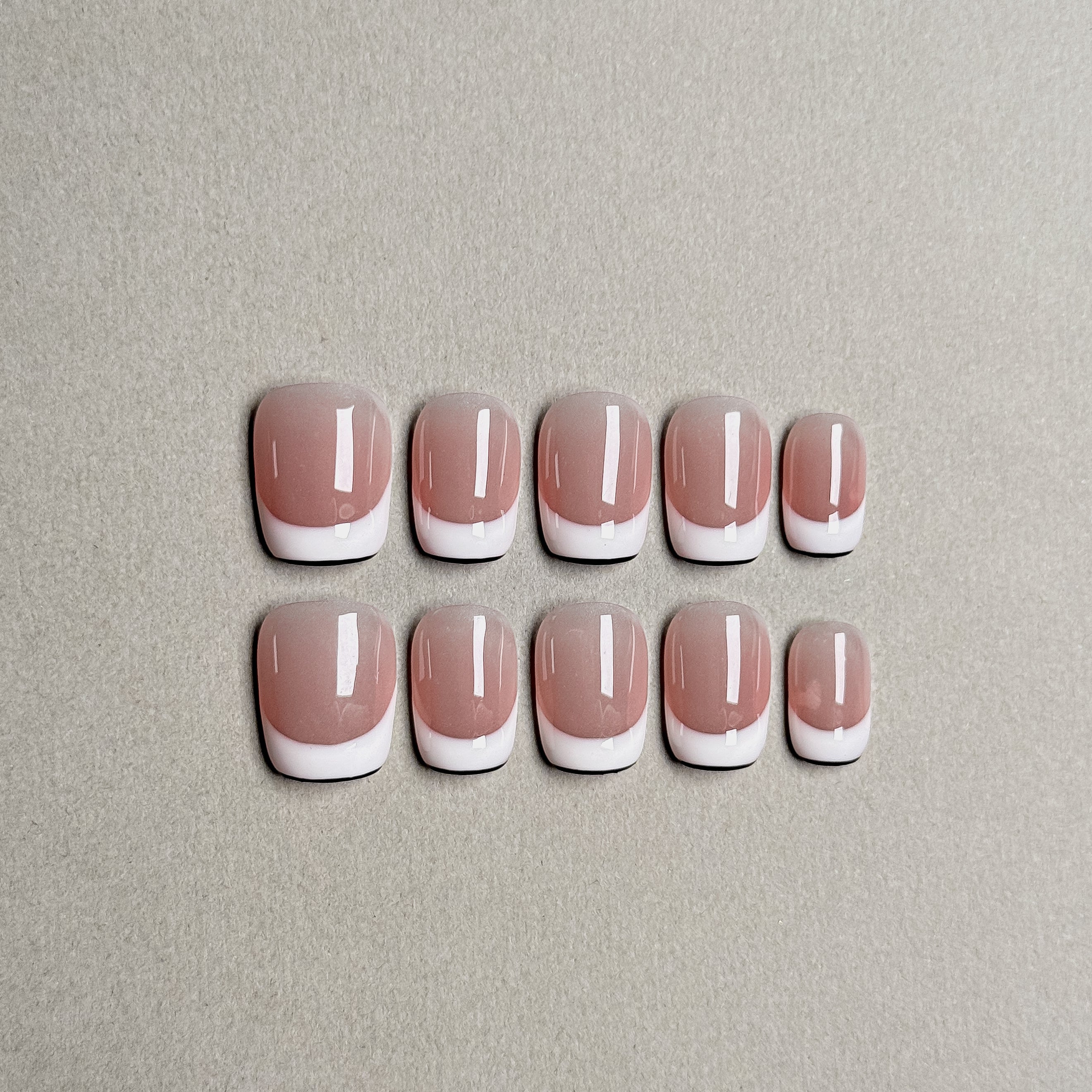 A set of "Up" press - on nails featuring a traditional French - tip design with a soft pink base and white tips, perfect for achieving an elegant look for daily wear or special occasions.