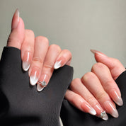 Hands displaying MIBLAB's Rhinestone nails in Stiletto nails shape with French tip nails design. Features nail accessories with subtle pink gradient. Ideal for wedding nails or party nails, showcasing luxury press on nails. Offers handmade press on nails with professional nail art detail and nail care tips.