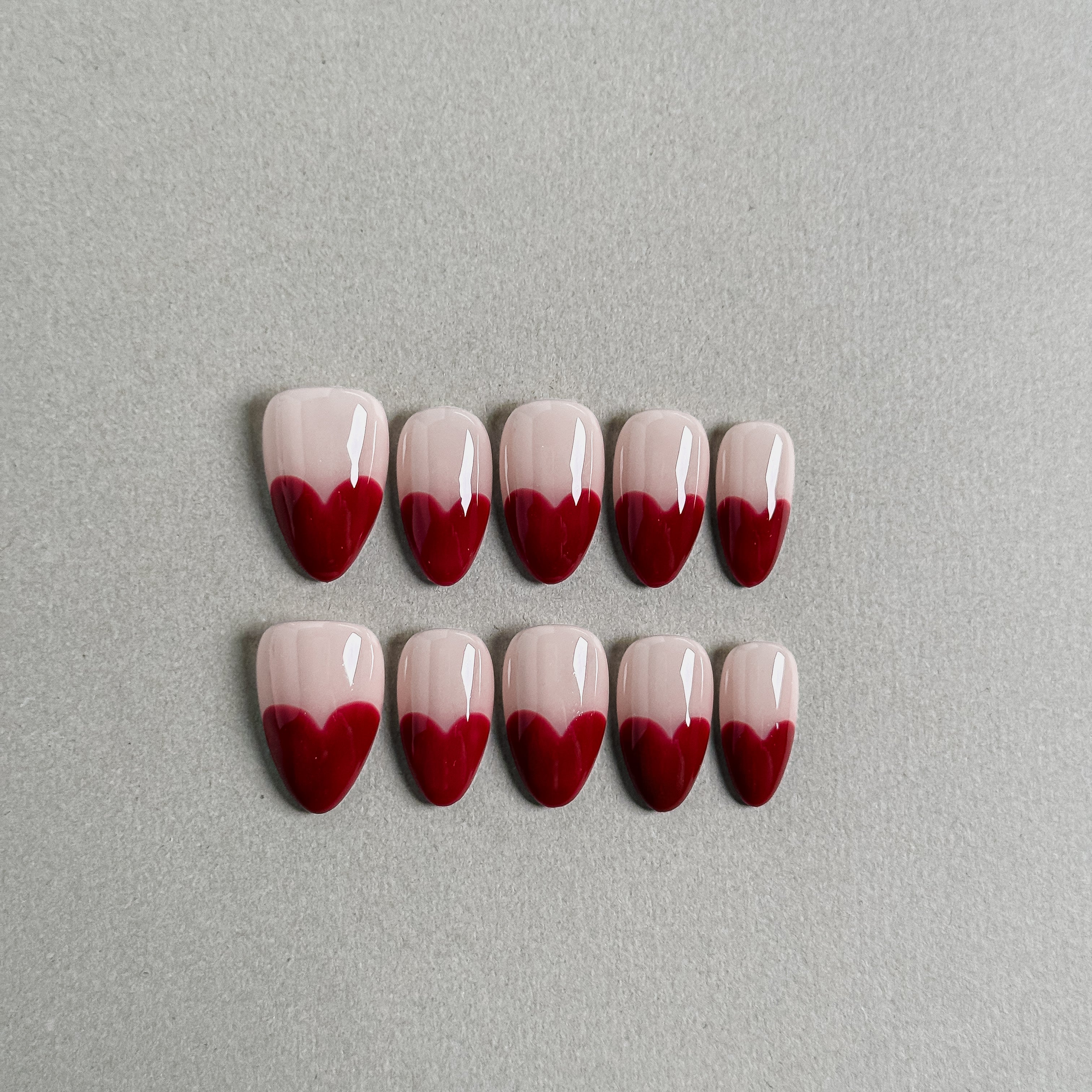 A set of "My Funny Valentine" press - on nails with a charming heart - shaped design at the tips, combining soft pink and deep red colors, perfect for romantic nail art styles like those for weddings.