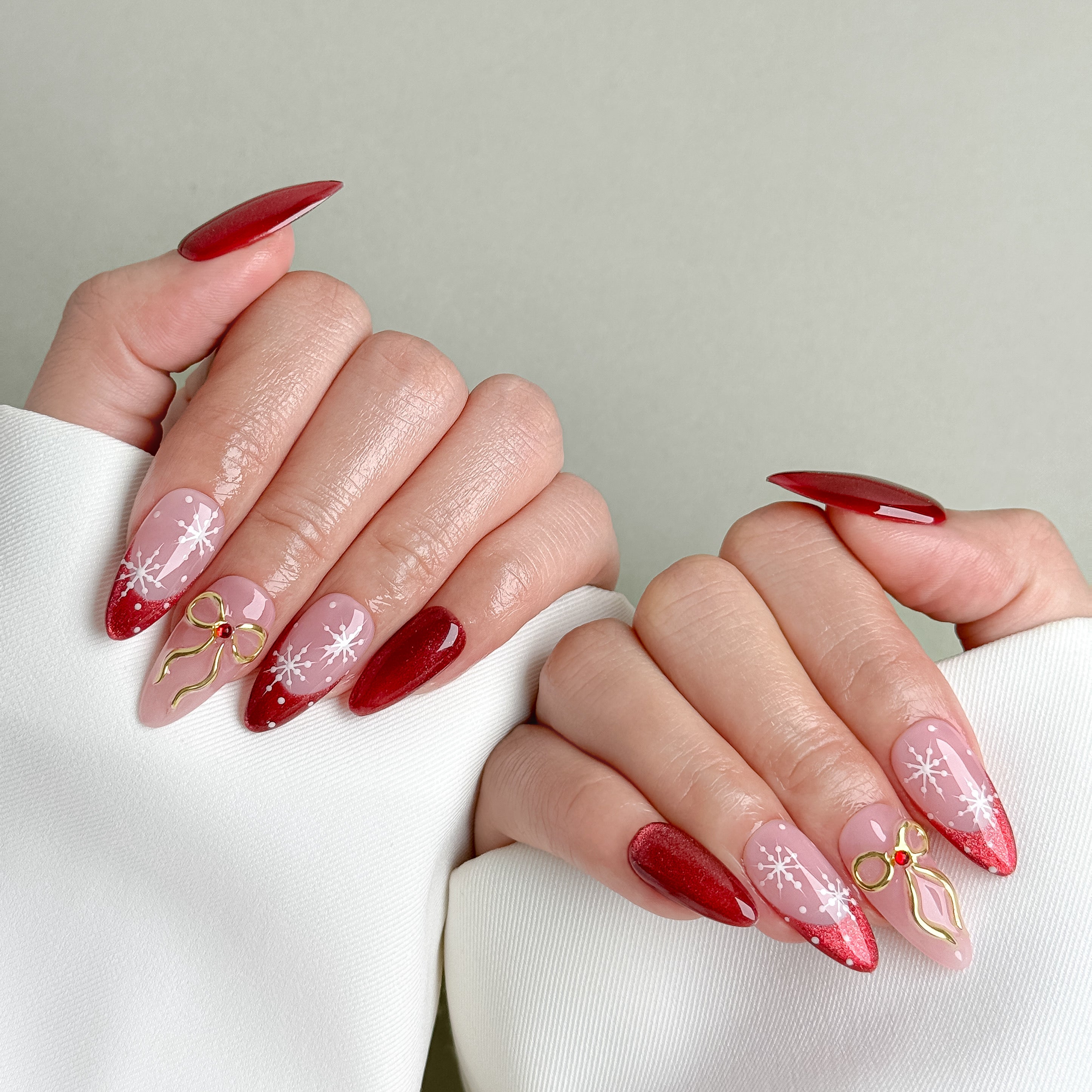Model wearing MIBLAB Last Christmas red and nude pink glitter press-on nails, handcrafted reusable design available in Geneva.