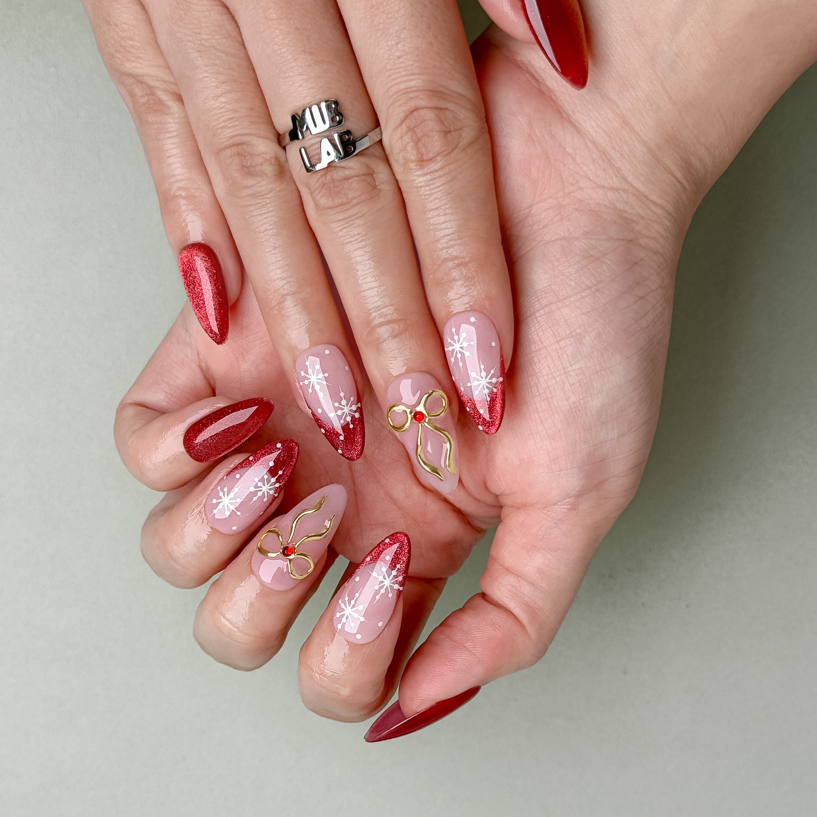 Elegant red and nude pink press-on nails with golden bow details, handcrafted reusable design by MIBLAB Geneva.