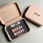 A set of Blush - named glittery custom press - on nails with a soft pink hue and shimmering glitter stripes, ideal for party and wedding nail art styles.