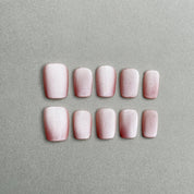 Two rows of MIBLAB's light pink press-on toenails with delicate pink floral designs, featuring a subtle shimmer and a glossy finish, arranged against a neutral gray background to highlight the intricate details and soft color palette, with a gradient of sizes from large to small for a perfect fit.