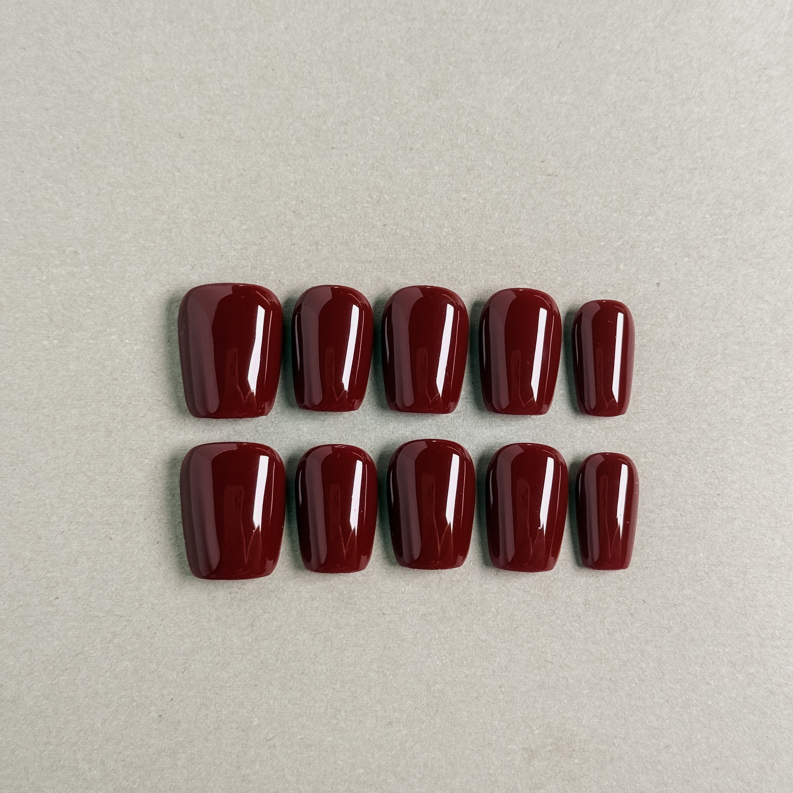 Luxury deep red coffin nails with a glossy finish. Reusable press-on nails, perfect for an elegant and sophisticated look. Ideal for party nails, professional nail art, and easy application with glue-on nails.
