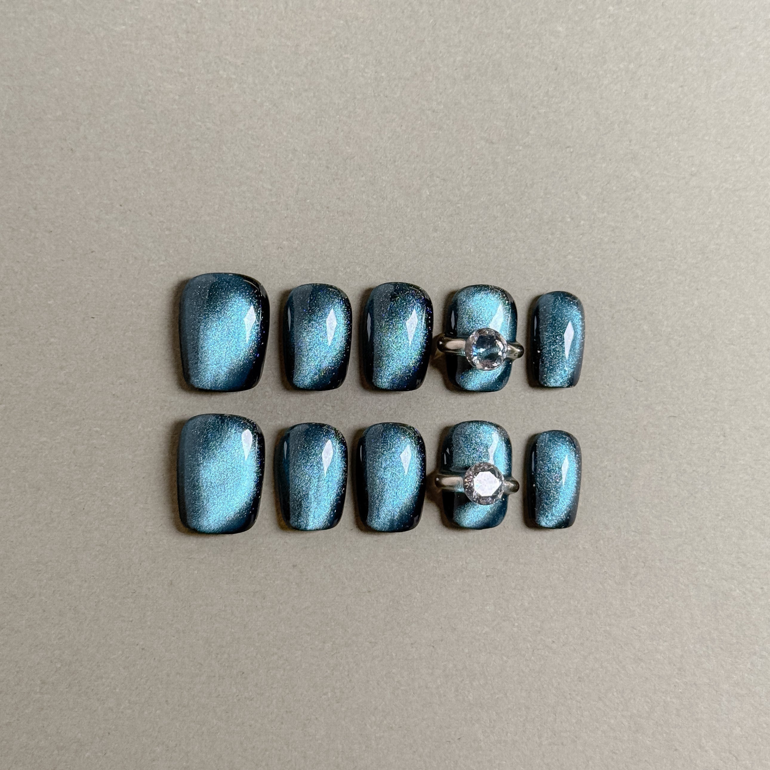 Gorgeous Stormy press on nails with a sleek, shimmering teal finish and a diamond ring accent, featuring Luxury press on nails and Glitter nails, perfect for Wedding nails
