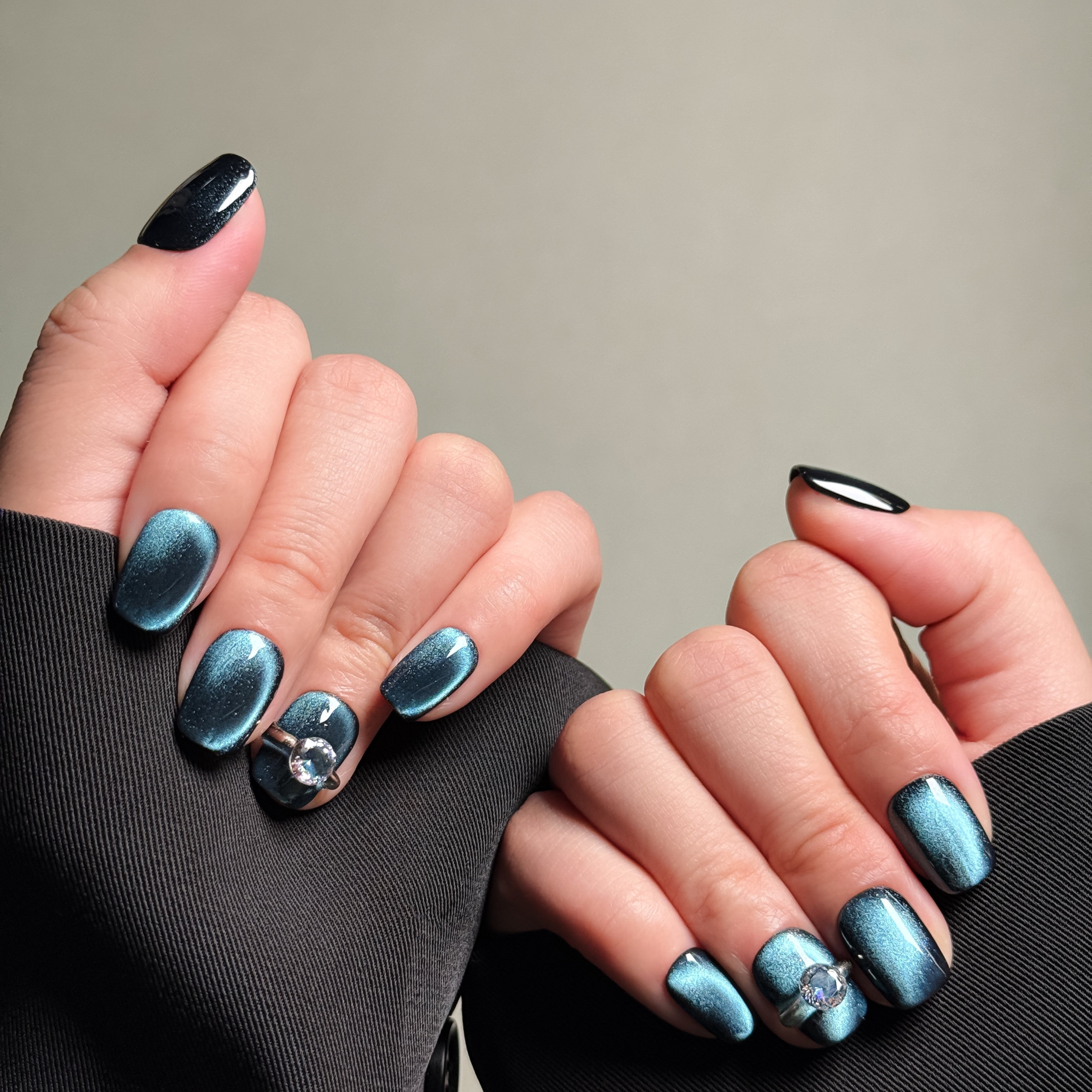 Elegant Oval nails featuring a deep teal finish with silver ring accents. These Luxury press on nails offer a bold and unique look, perfect for Party nails or special occasions. The cat-eye effect and silver accents make them the focal point of any look. Perfect for those seeking Custom press on nails that are both stylish and eye-catching.
