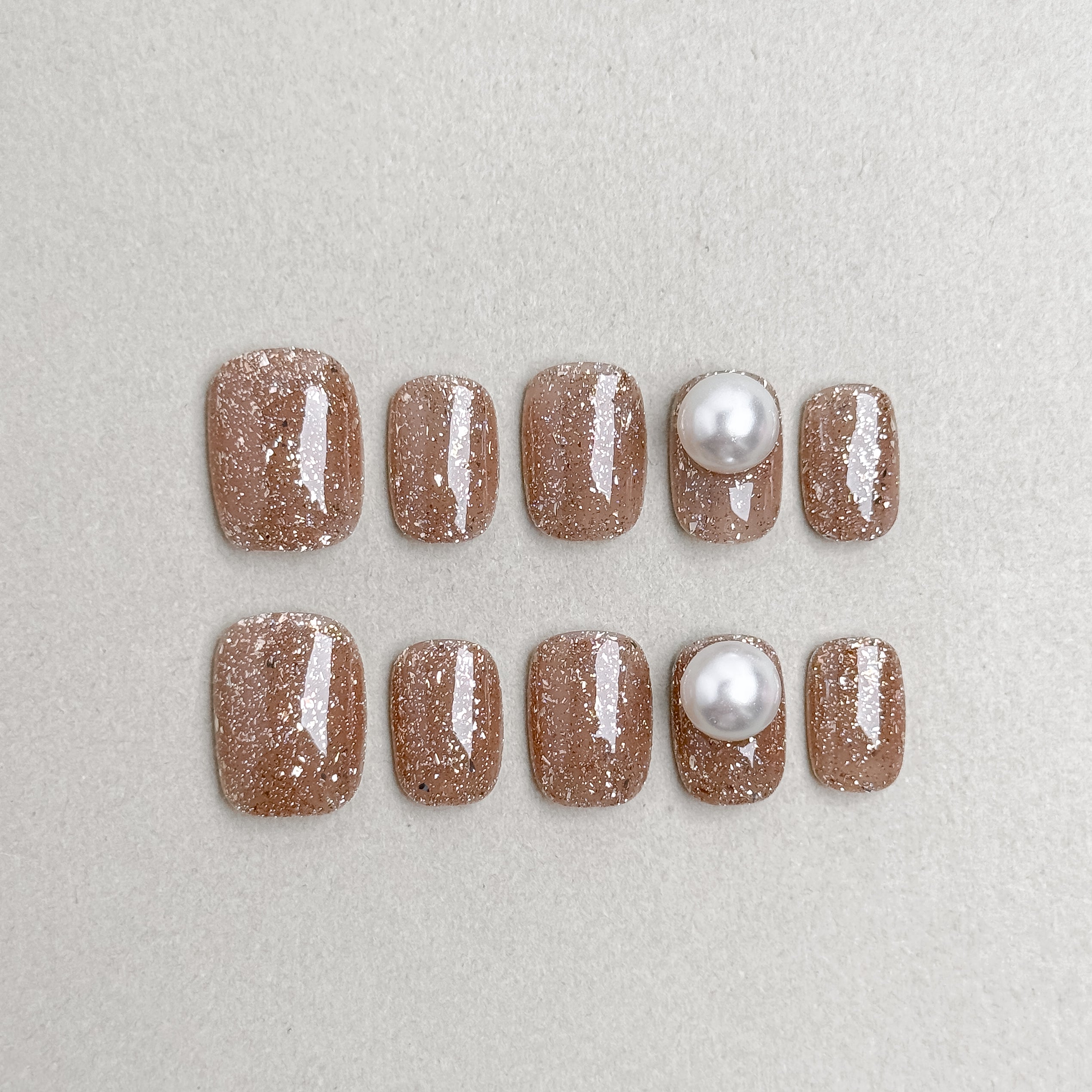 Set of reusable press-on nails in warm beige with glitter and pearl accents, MIBLAB Me Time collection Geneva.