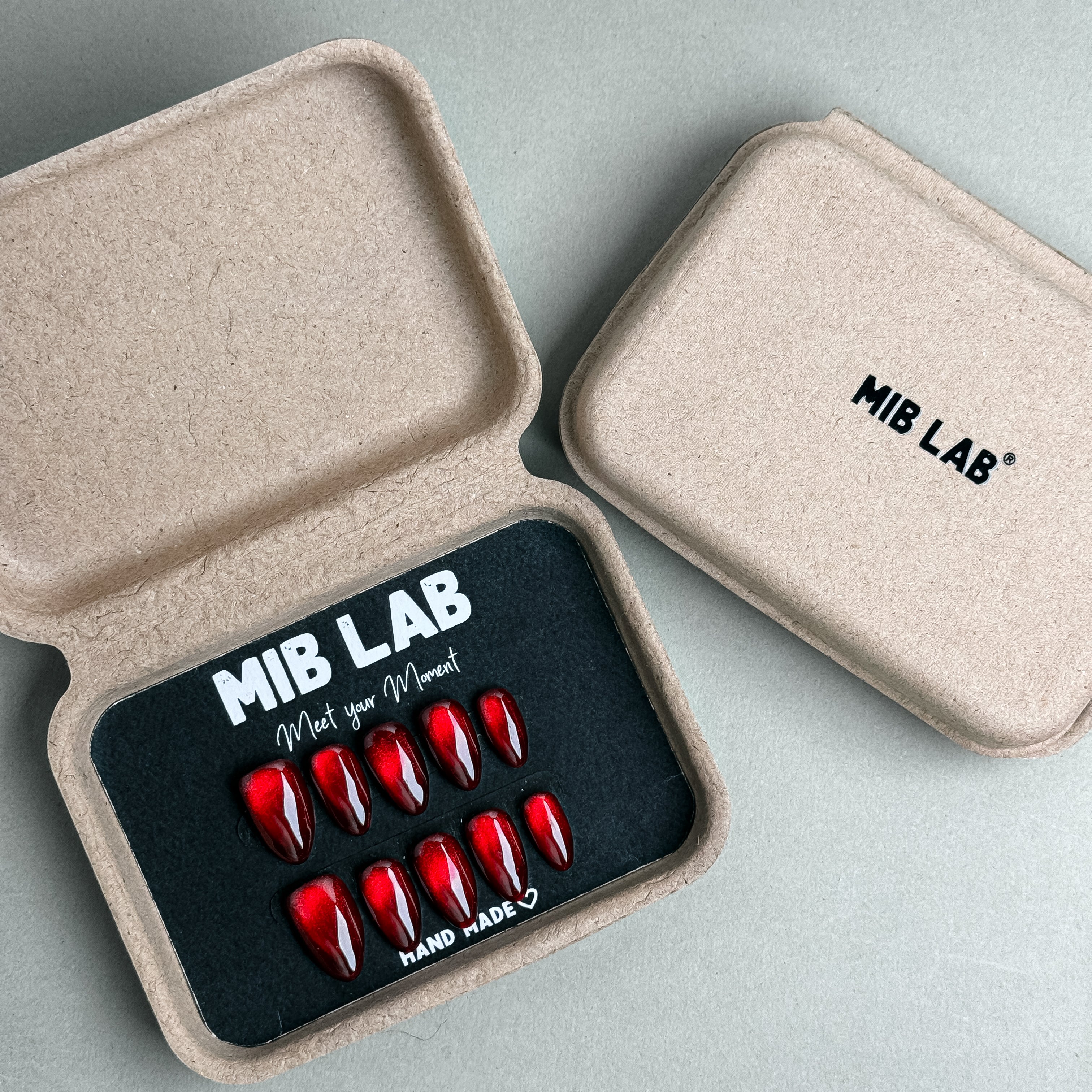 MIBLAB Merry Me press-on nail set in bright metallic red tone, packaged for boutique display in Geneva.