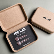  A set of Handmade press on nails designed for toes, featuring a soft pink color, presented in eco-friendly packaging. These Natural looking nails offer a clean and polished look, perfect for everyday wear. The box, labeled "MIB LAB" and "Meet Your Moment", highlights the brand's dedication to creating personalized Nail art designs for all occasions. Ideal for those seeking Reusable fake nails that combine style and sustainability for their toes.