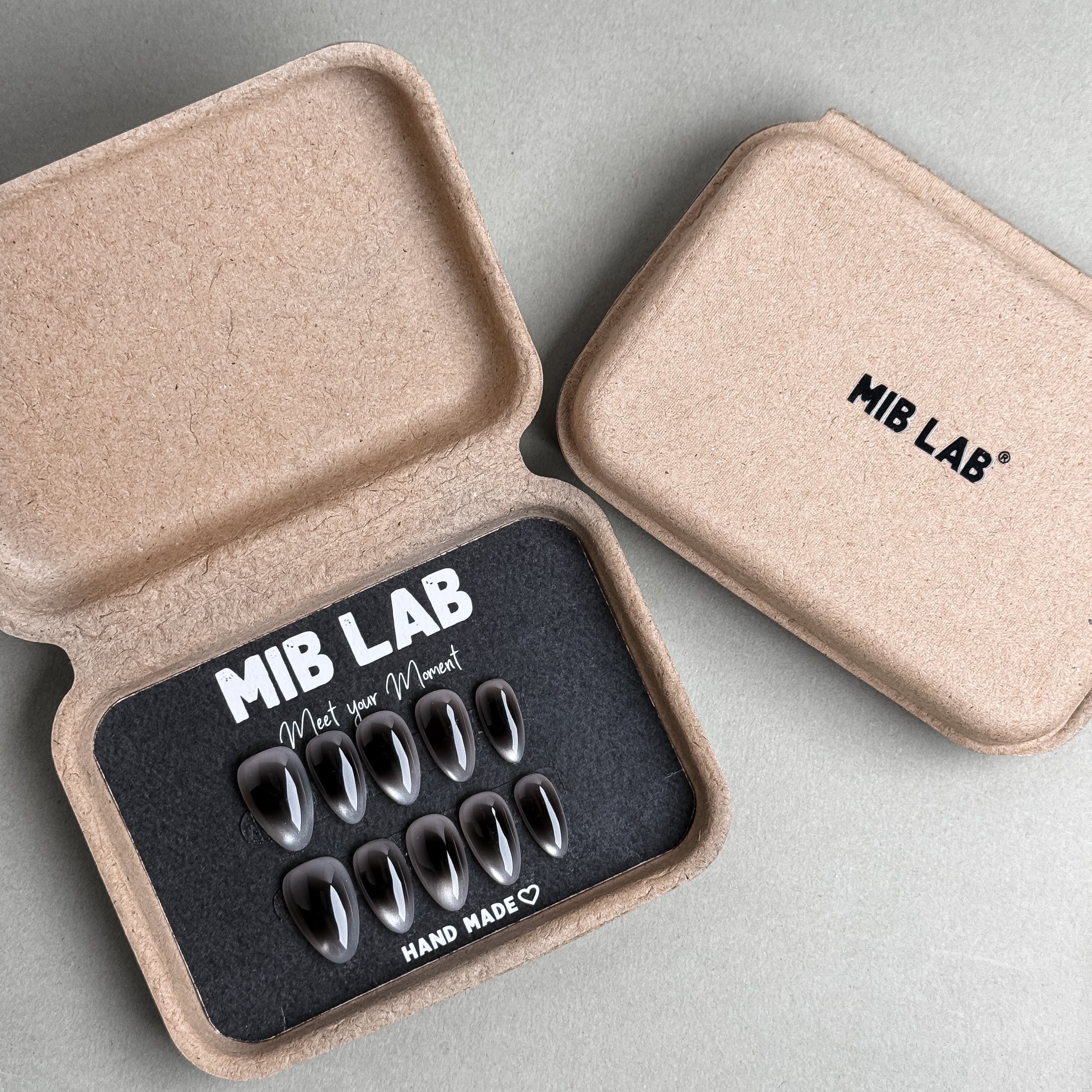 MIBLAB Raw press-on nail set with sleek gray chrome tone, packaged for boutique display in Geneva.