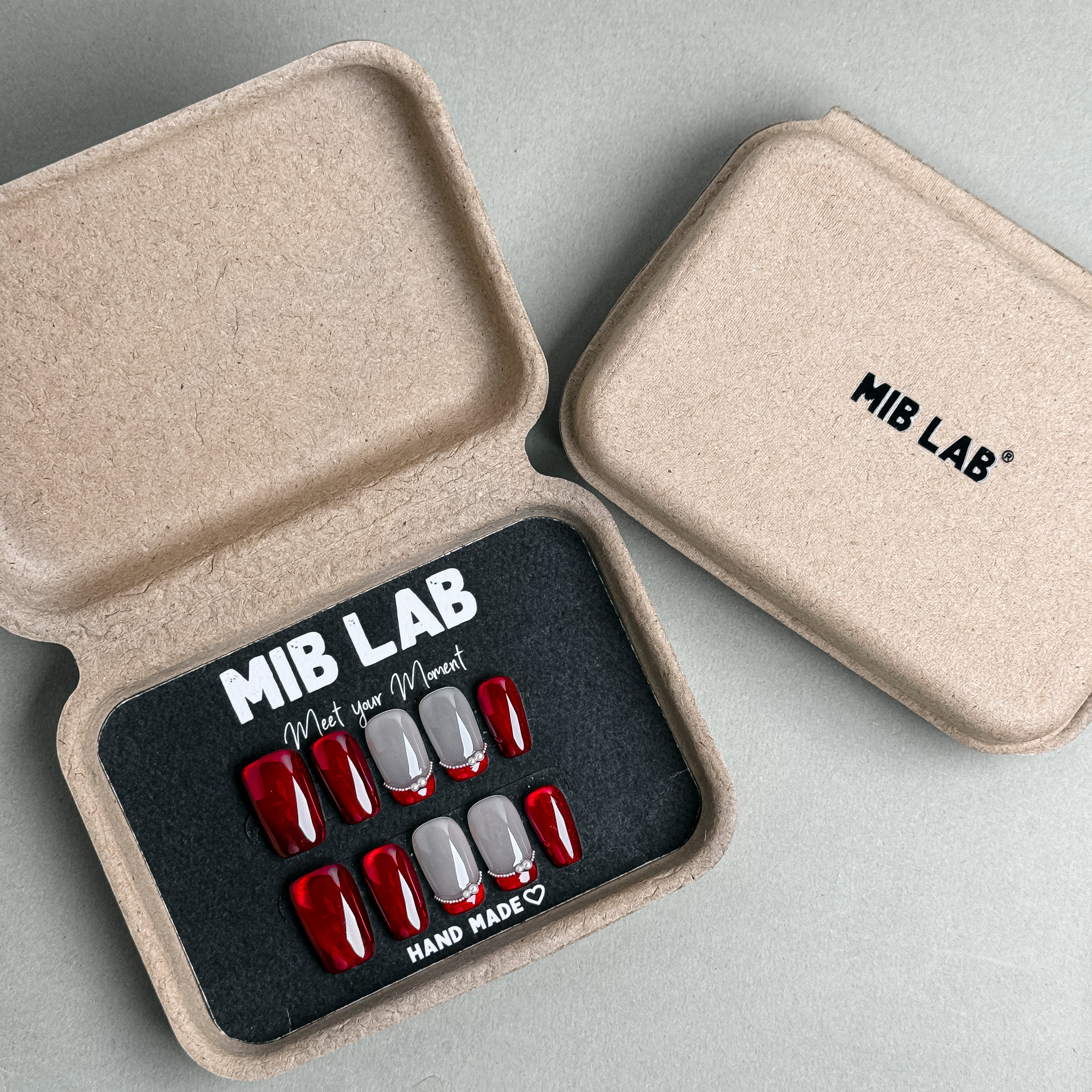 MIBLAB Round Midnight press-on nail set with elegant red and nude tones, packaged for boutique display in Geneva.
