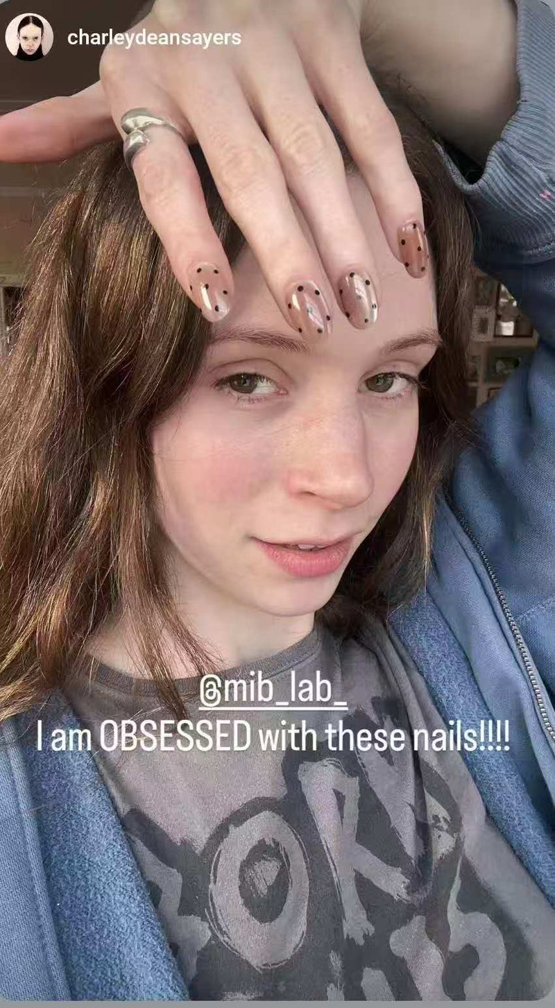 Woman wearing nude metallic press-on nails with black dot design by MIB LAB showing reusable premium press-on manicure