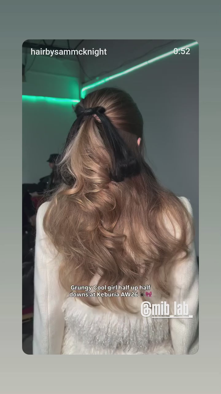 Backstage défilé : coiffure en cours sur un modèle aux longs cheveux bleus (half-up half-down), avec mention Keburia AW26 et tag @mib_lab.