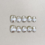 The Light : faux ongles réutilisables nude transparent, détails blancs et reflets perlés, press on nails premium, finition brillante.