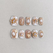 Stillness : faux ongles réutilisables nude laiteux, fleurs blanches et touches dorées, press on nails premium, finition brillante.