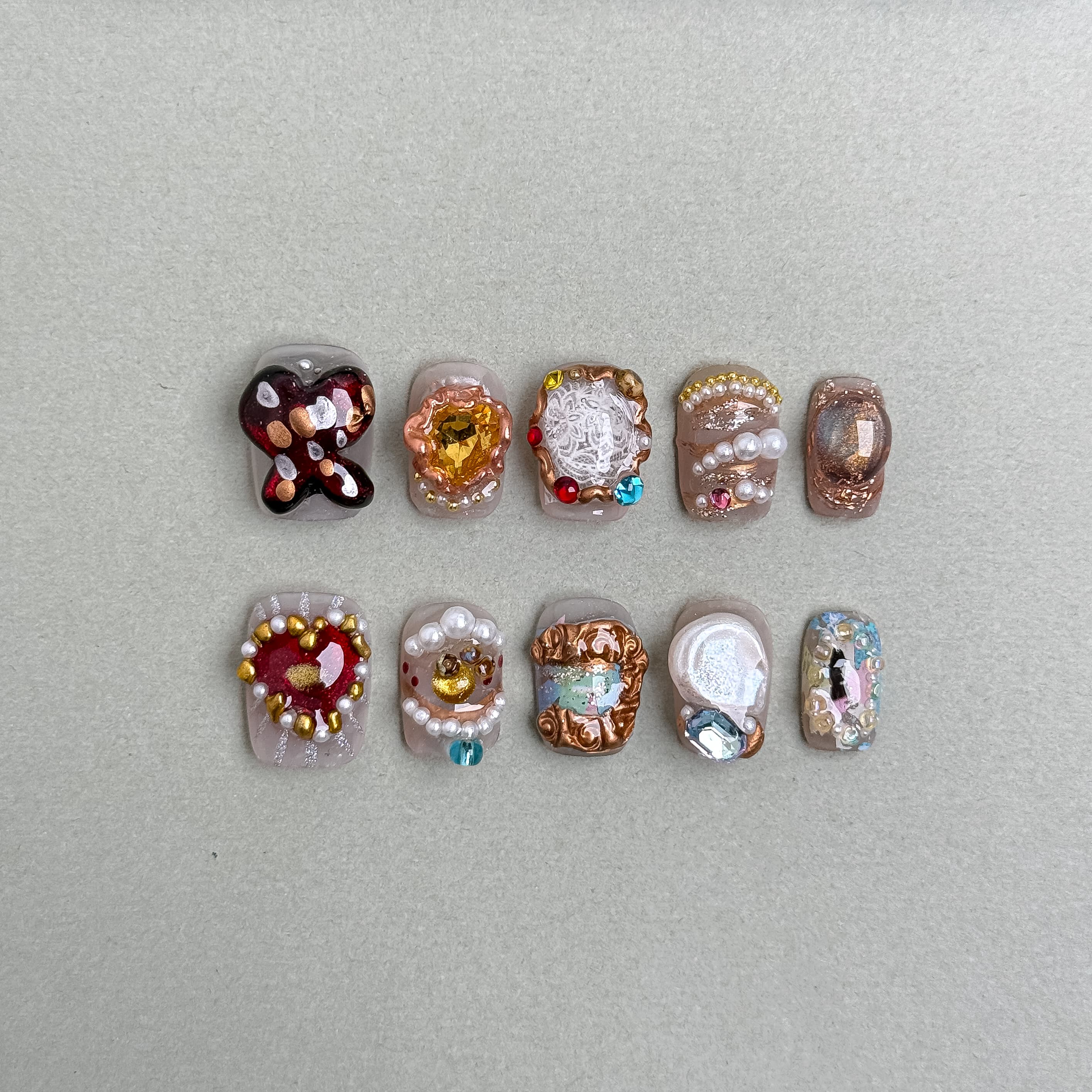 Heir : faux ongles réutilisables multicolores style bijou, motifs floraux et perles, accents dorés, press on nails premium.