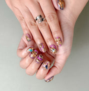 Manucure Crown portée : press on nails violet-or, look luxueux et audacieux, ongles sans gel, Genève.