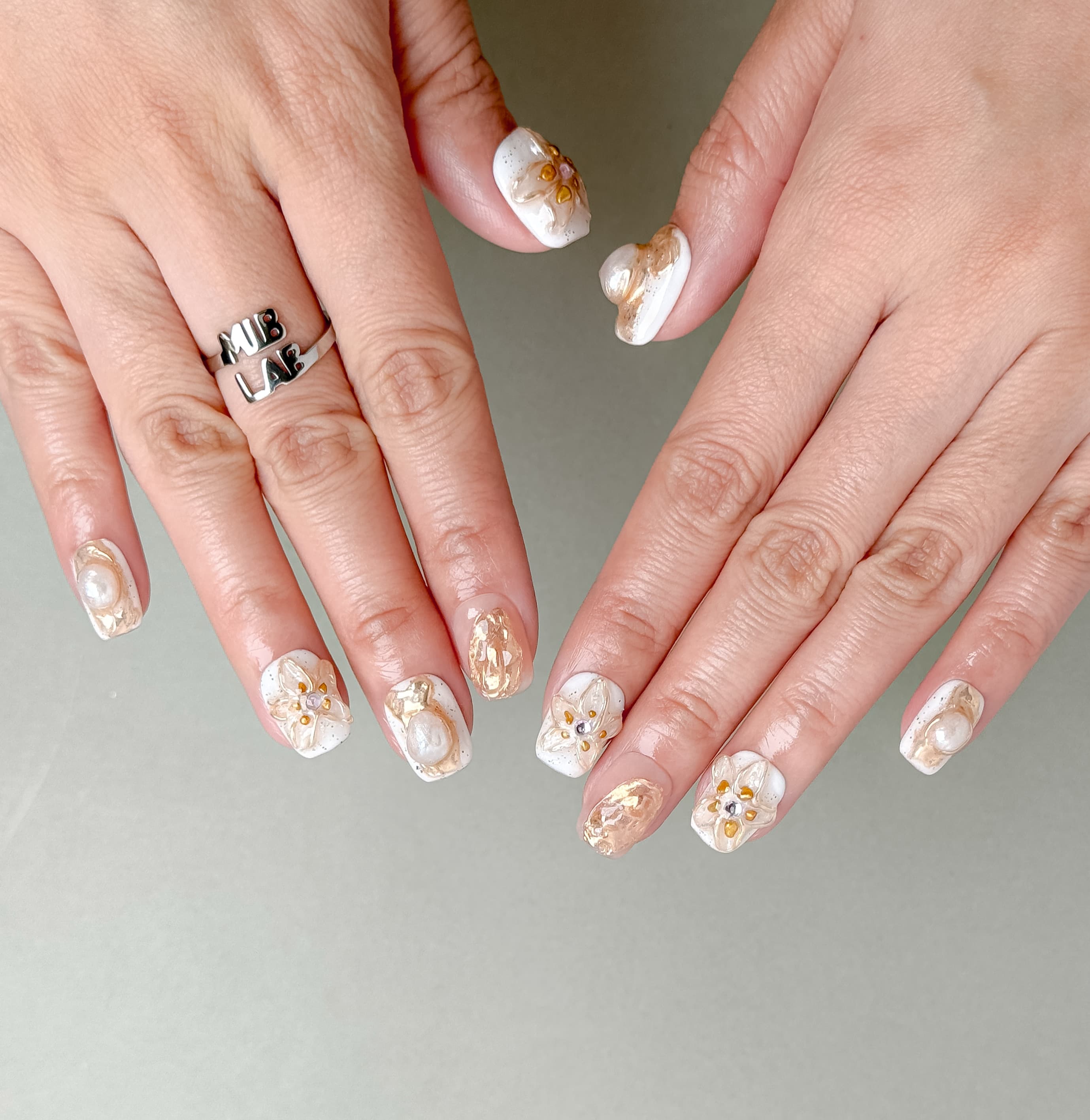 Stillness sur mains : faux ongles réutilisables nude, design floral minimal chic, manucure rapide, Genève et Suisse.