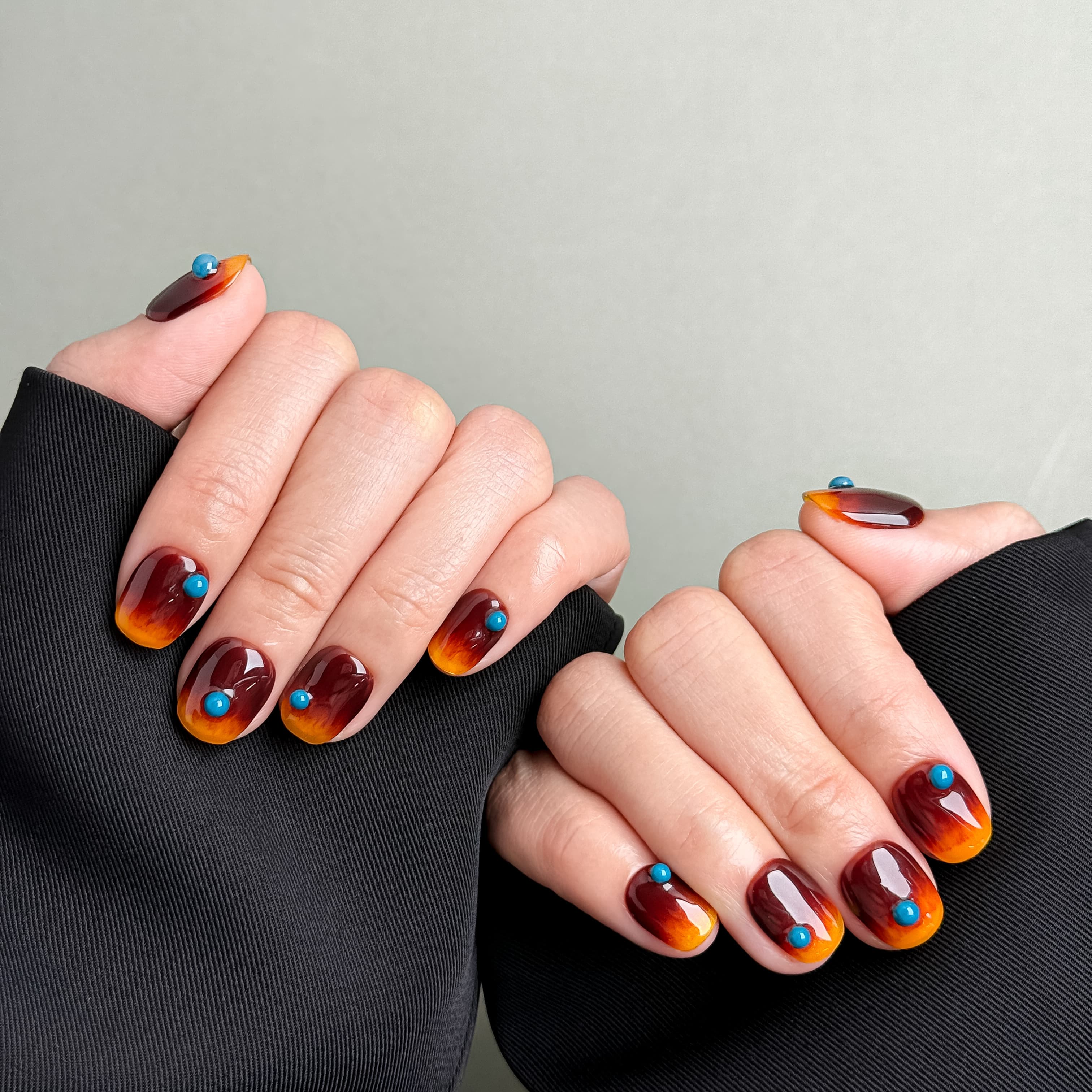 Manucure How it’s Done portée : press on nails ambre à contour noir, look audacieux et chic, ongles sans gel, Genève.