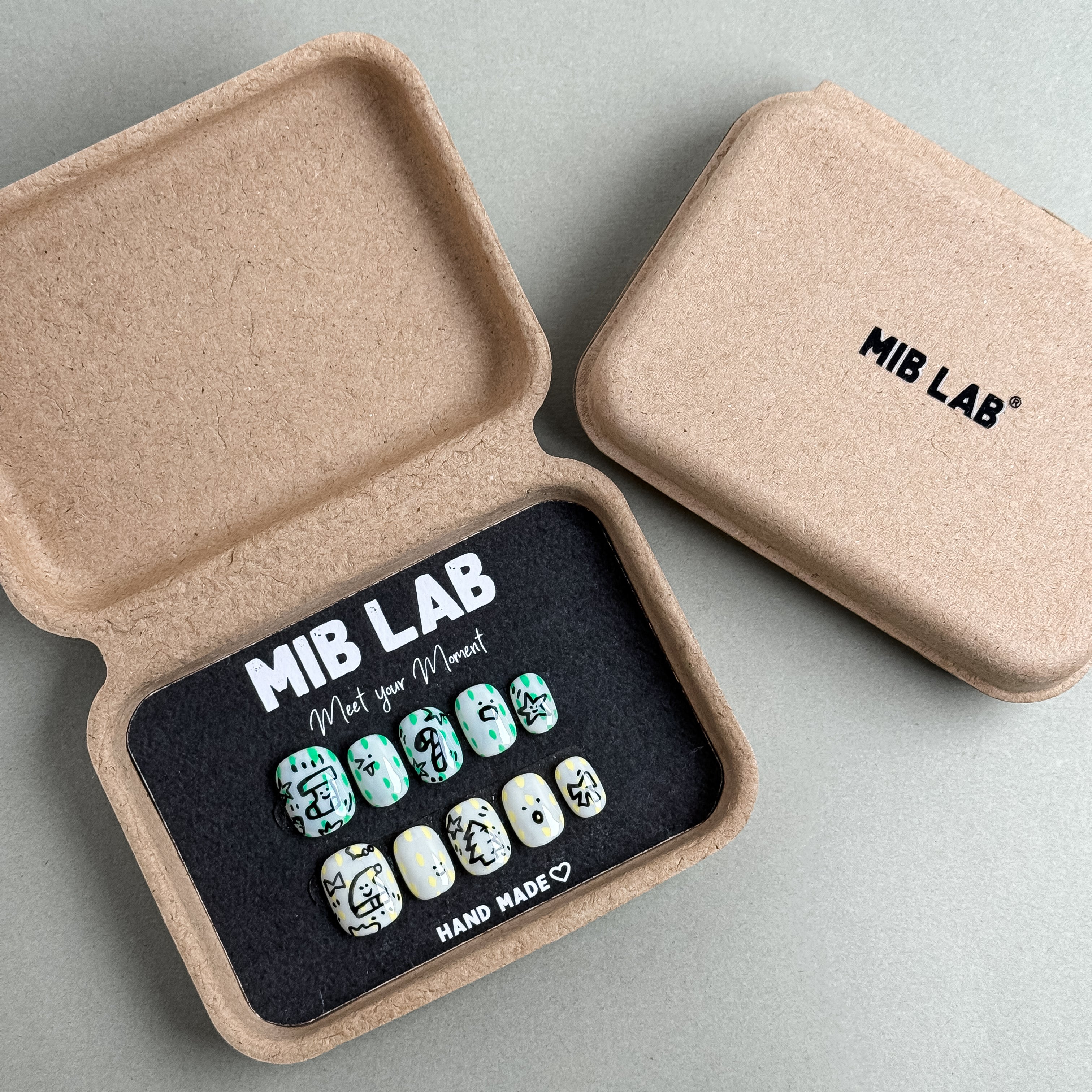 MIBLAB Jolly Cookie press-on nail set featuring festive cookie and icing patterns in mint green and cream tones, packaged for boutique display in Geneva.
