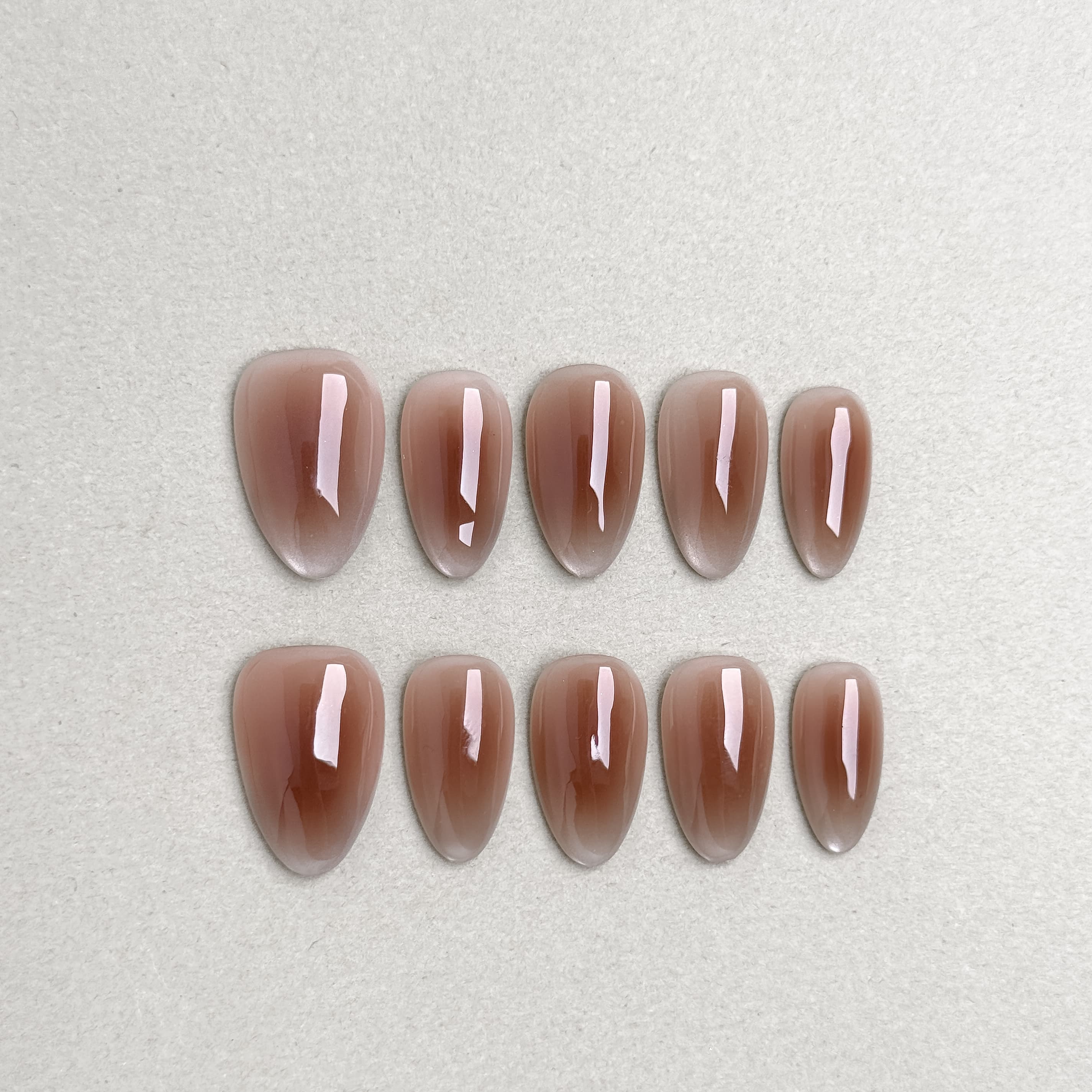 Glossy brown press-on nails inspired by cinnamon tones from the Cinnamon Roll set