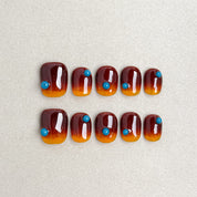 How it’s Done : faux ongles réutilisables dégradé ambre-orange avec bord noir, press on nails premium, finition brillante.