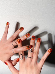 Détail She Is Fire sur mains : faux ongles premium réutilisables fini glossy, style soirée, tenue longue durée, Suisse.