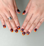 Gros plan How it’s Done : faux ongles réutilisables dégradé ambre, bord noir net, finition glossy, Suisse.