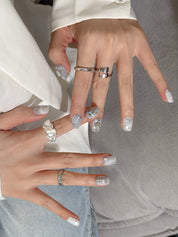 Détail Instinct sur mains : faux ongles premium réutilisables perlé, accents brillants, style soirée, Suisse.