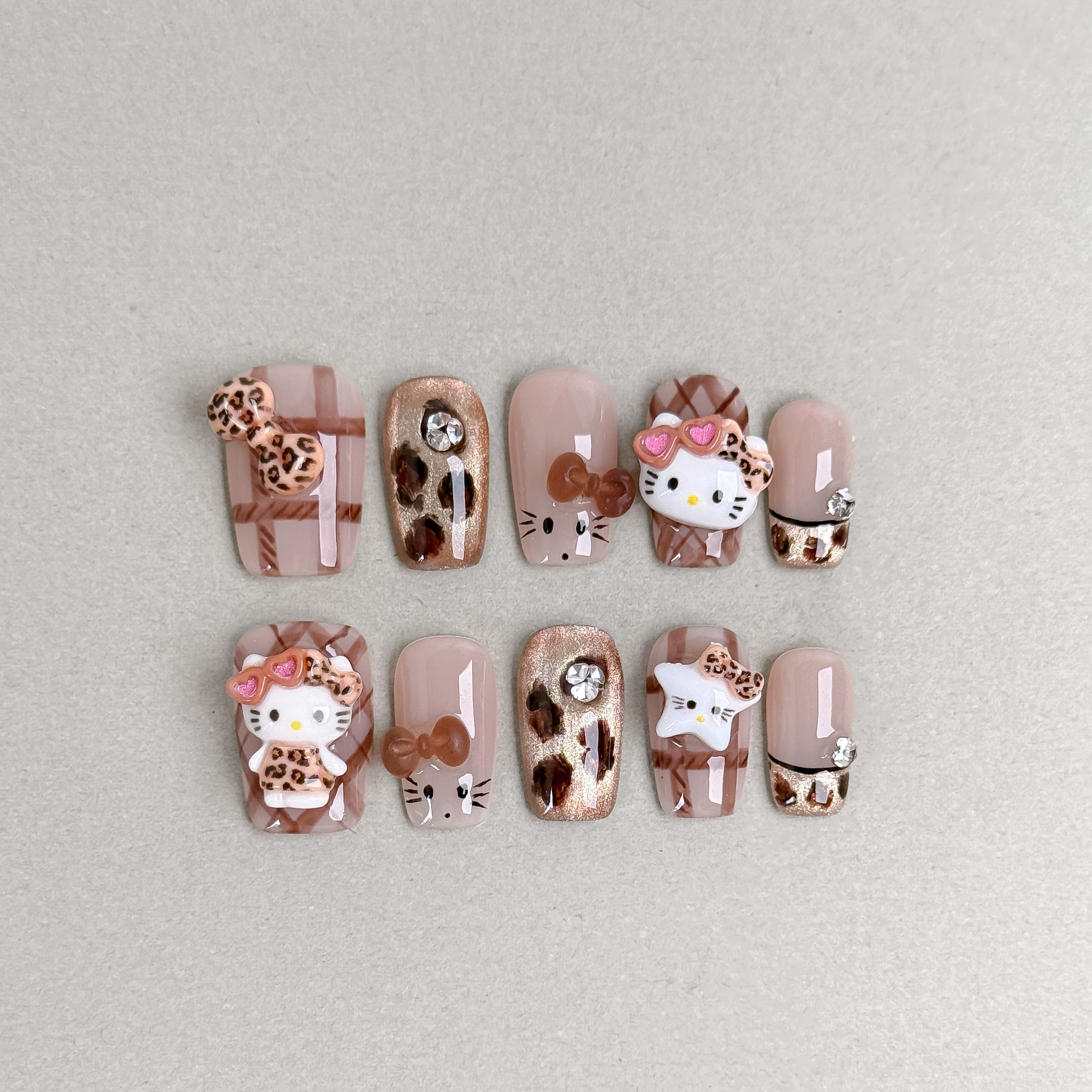 Cute pink and beige 3D press-on nails with Hello Kitty and bow accents named Dream a Little Dream