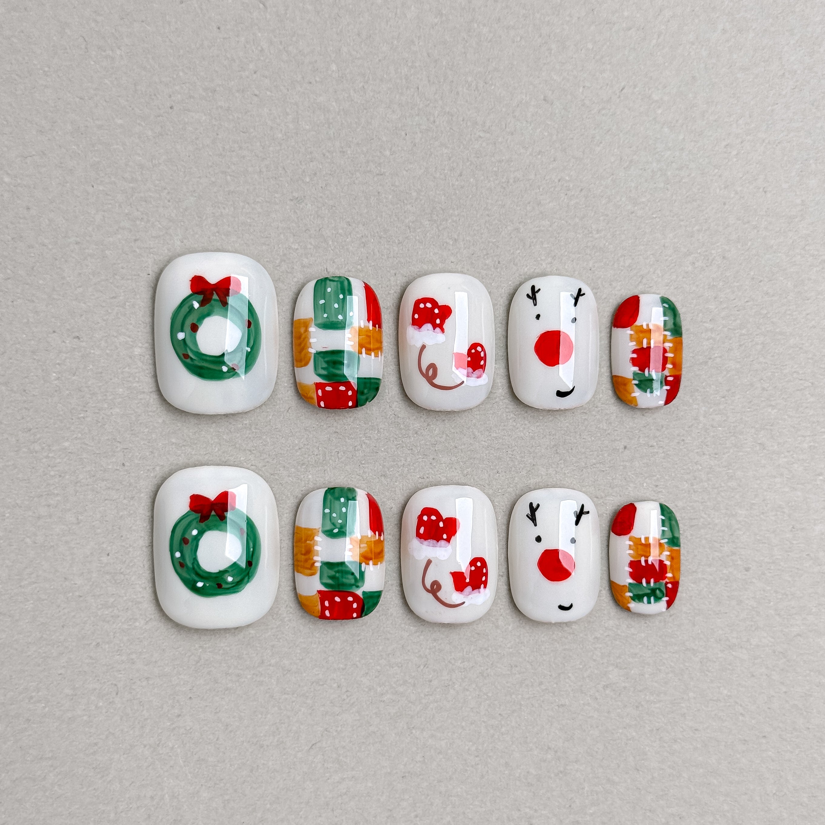 Set of reusable press-on nails with Christmas wreath, gift box, and snowman designs in white, red, and green, MIBLAB Let It Snow collection Geneva.