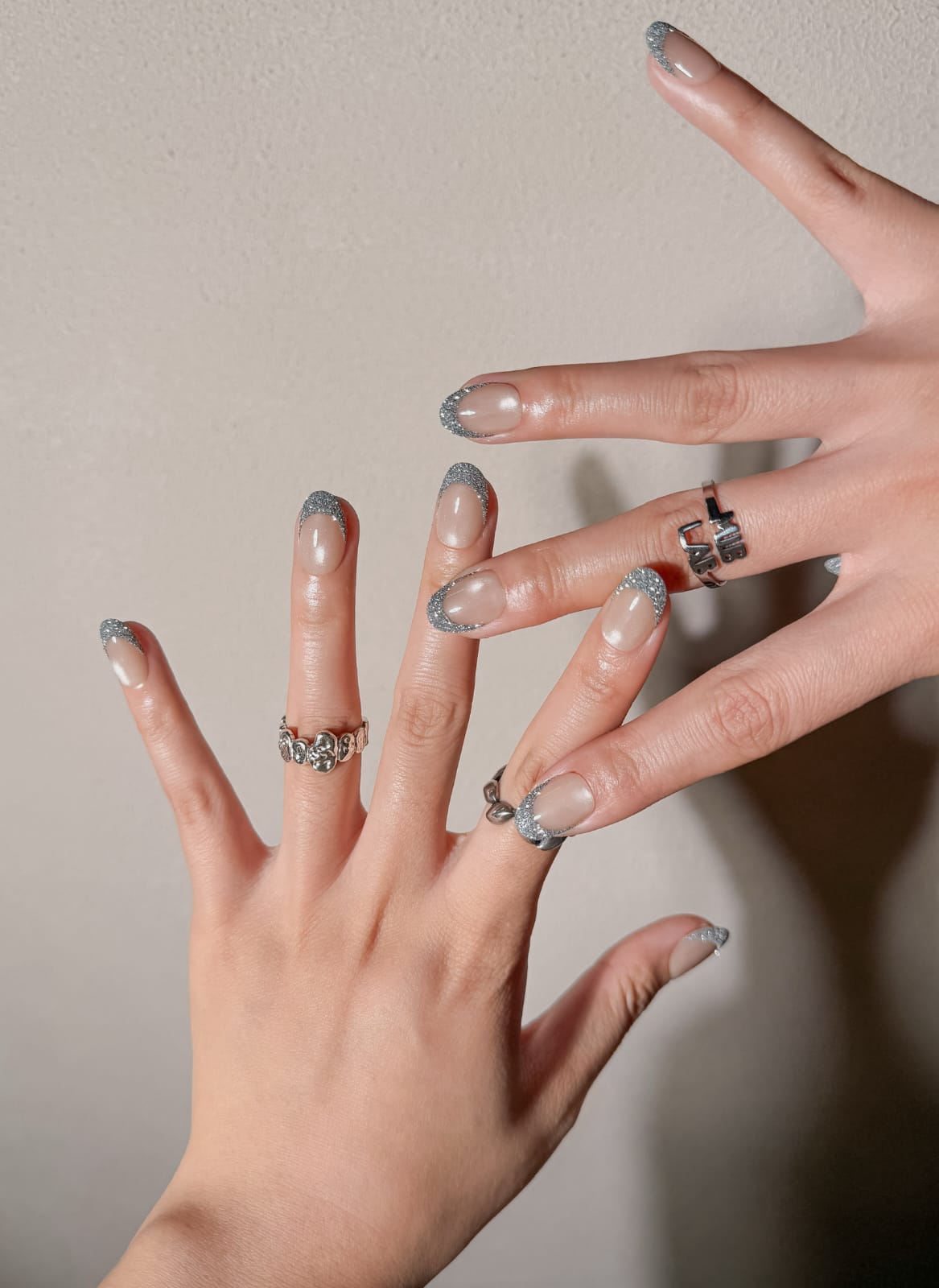 Manucure Éveil portée : press on nails nude nacré avec contour argent, look élégant et lumineux, ongles sans gel, Genève.