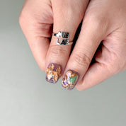 Gros plan Crown : faux ongles premium réutilisables avec motifs arty et touches dorées, style soirée, Suisse.