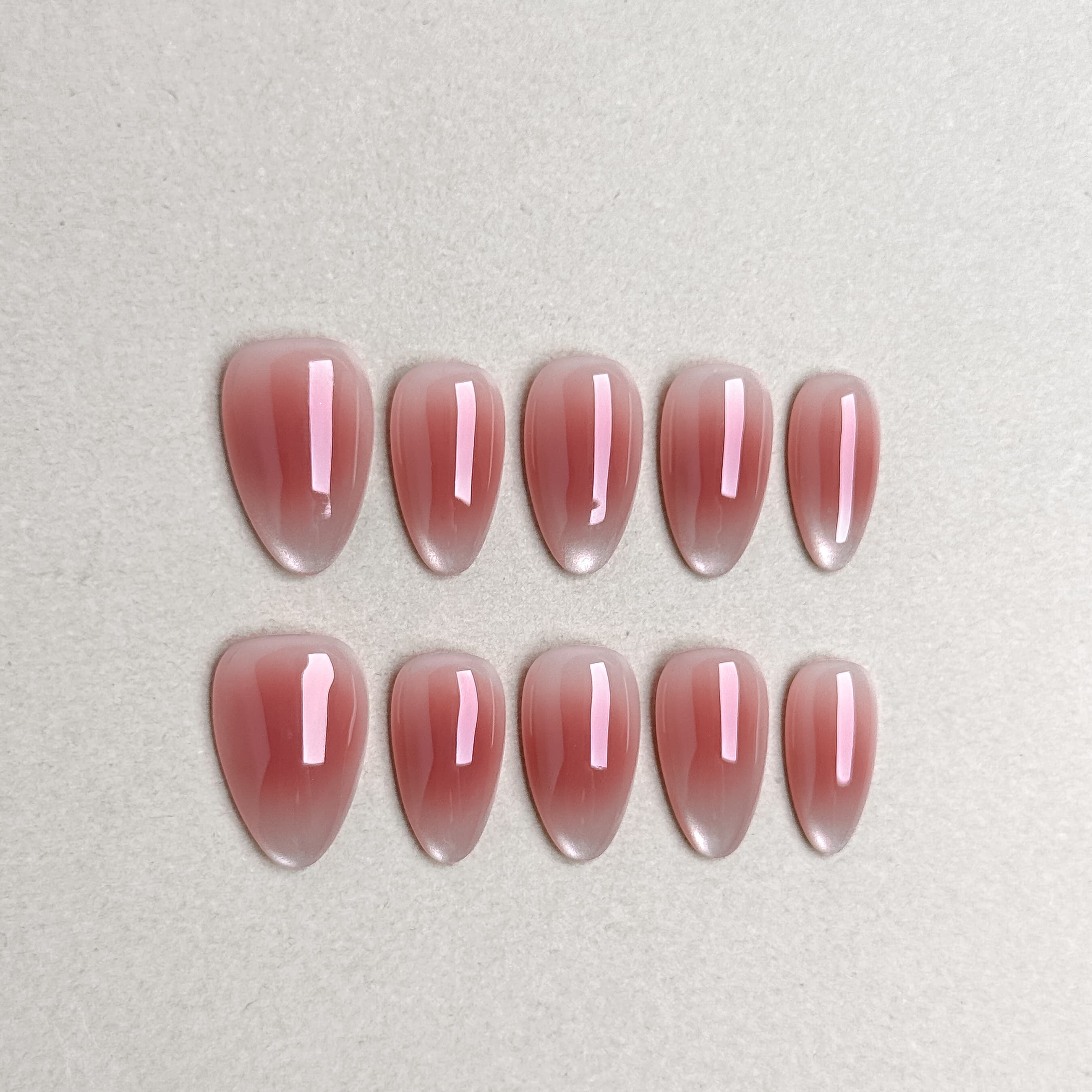 Rose-pink glossy press-on nails from the Mood for Love set arranged on a flat background