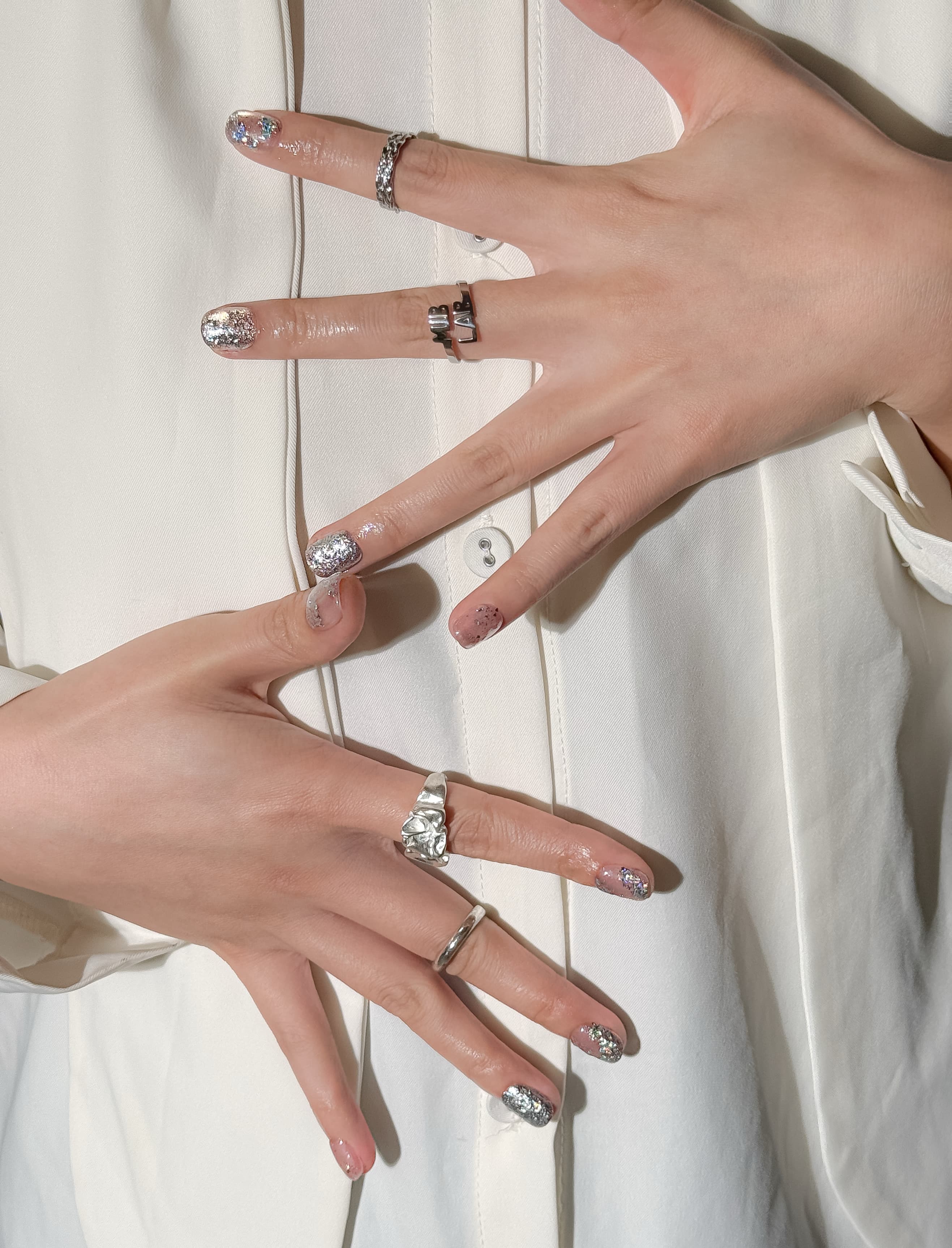 Manucure Splash portée : press on nails nude pailleté argent, look élégant et lumineux, ongles sans gel, Genève.