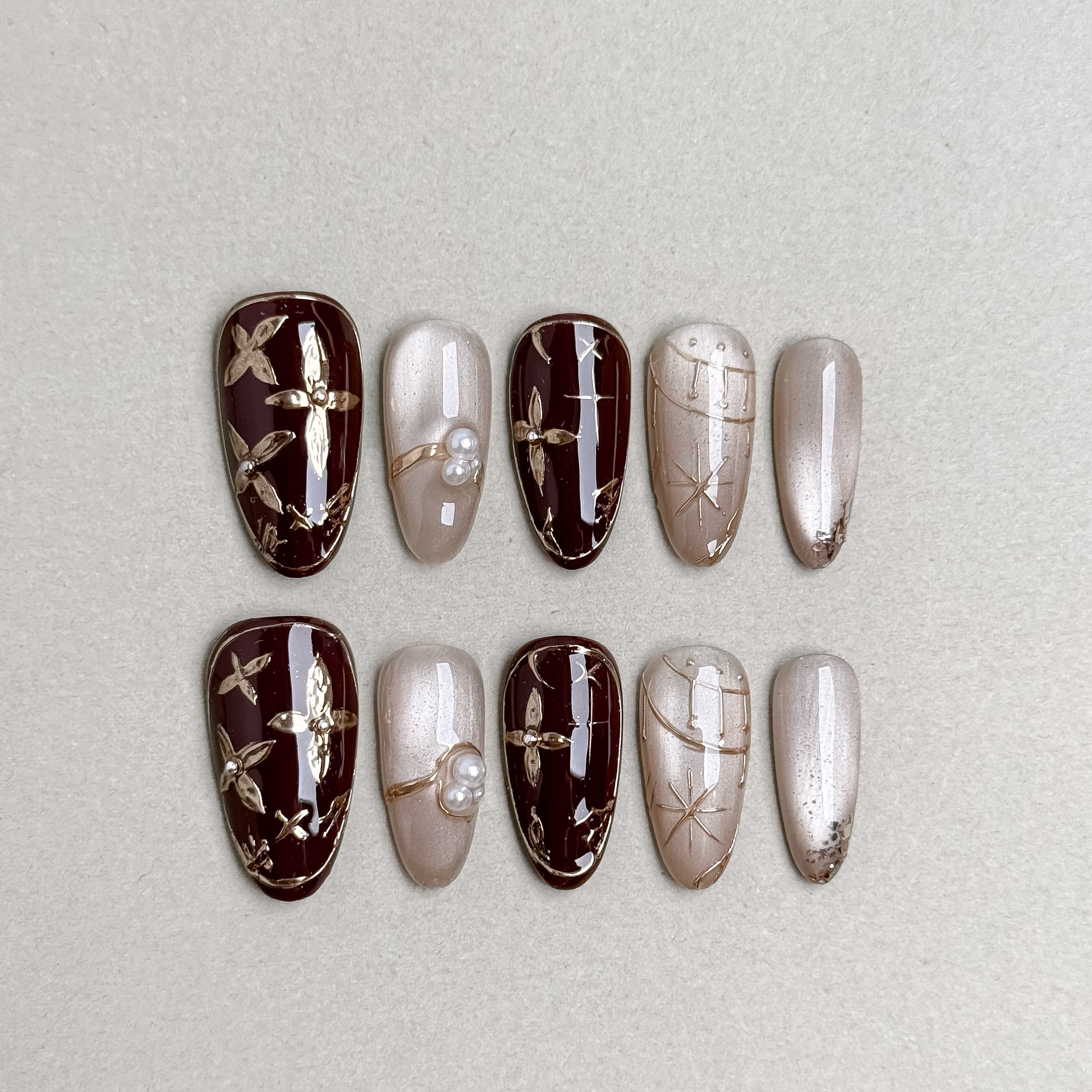 Wood-grain and metallic silver press-on nails displayed on a neutral background